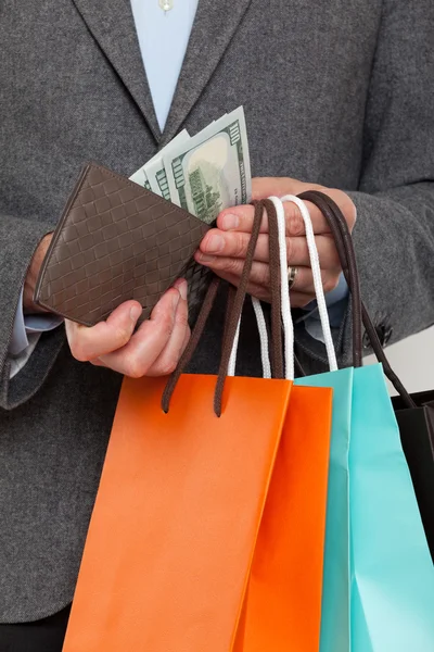 Primer plano de un hombre de compras con dinero en efectivo en la mano — Foto de Stock