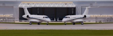 Bir hangar önünde iki özel uçak