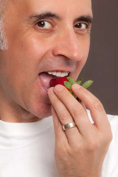 Человек ест клубнику крупным планом — стоковое фото