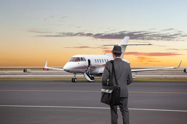 Hombre de negocios caminando hacia un jet privado — Foto de Stock