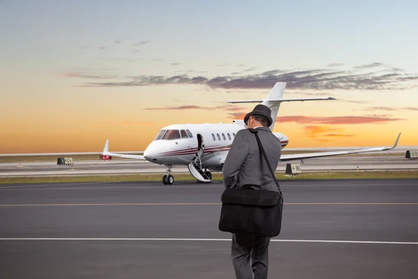 Hombre de negocios caminando hacia un jet privado — Foto de Stock