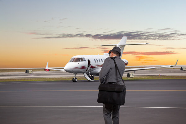 Business man walking toward a private jet