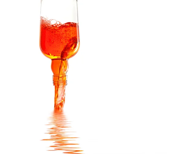 Transparent glass bottle pouring liquid on water — Stock Photo, Image