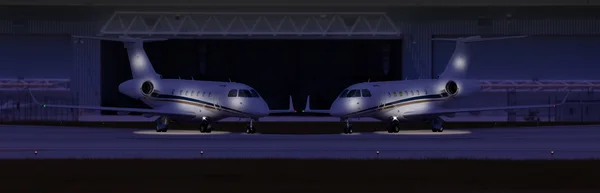 Gece bir hangarda önünde iki özel uçak