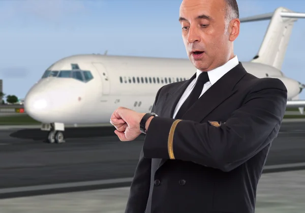 Apuesto trabajador de la aerolínea mirando su reloj — Foto de Stock