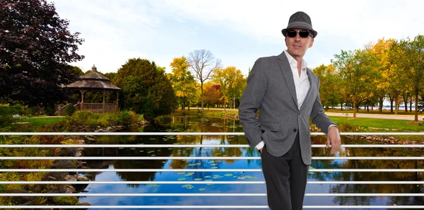 Homme à la mode debout près d'un pont à l'automne — Photo
