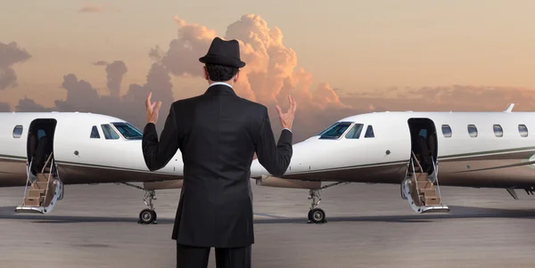 Business man in front of two private jets