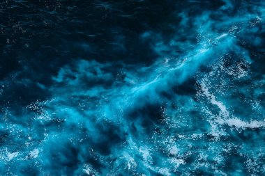 Okyanustaki su sıçrayan dalgaların hava görüntüsü. Mavi temiz dalgalı deniz suyu