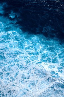 Okyanustaki su sıçrayan dalgaların hava görüntüsü. Mavi temiz dalgalı deniz suyu