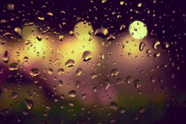 Gece lambasının yağmur damlalı soyut dairesel bokeh arkaplanı