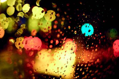 Gece lambasının yağmur damlalı soyut dairesel bokeh arkaplanı