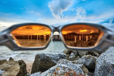 Turuncu lensli güneş gözlüğüyle deniz manzarası. Sahilde güneş gözlüğü