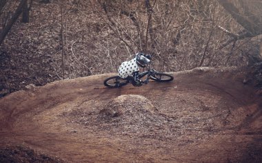 Moskova, Rusya - 10 Nisan 2019: Motosikletli agresif virajlar aldı. Dağ bisikleti bisikletçisi ormanda tek bir yolda gidiyor. Dağ bisikleti sporunda yarışan bir sürücü. Bisikletli bir sporcu. MTB bisikleti.