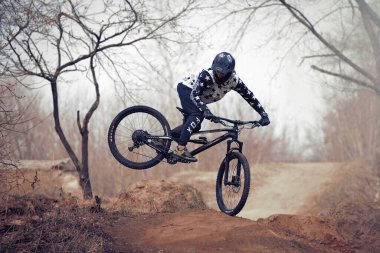 Moskova, Rusya - 12 Nisan 2019: Atla ve dağ bisikletiyle uç. Dağ bisikleti sporunda yarışan bir sürücü. Doğada bisiklete binen biri. Bisikletli havalı bir sporcu. MTB bisikleti.