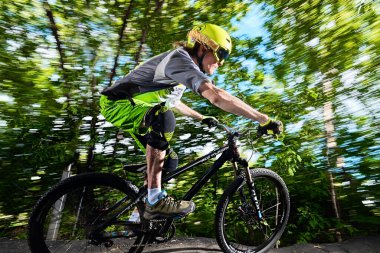 Moskova, Rusya - 10 Ağustos 2017: saldırgan bir motorcu. Dağ bisikleti bisikletçisi yolda gidiyor. Dağ bisikleti sporunda yarışan bir sürücü. Bisikletli havalı bir sporcu. MTB bisikleti.