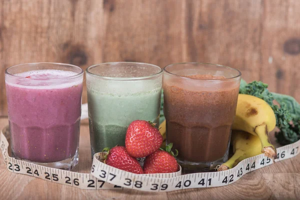 Tre smoothie skakar med bananer och jordgubbar med measuri — Stockfoto