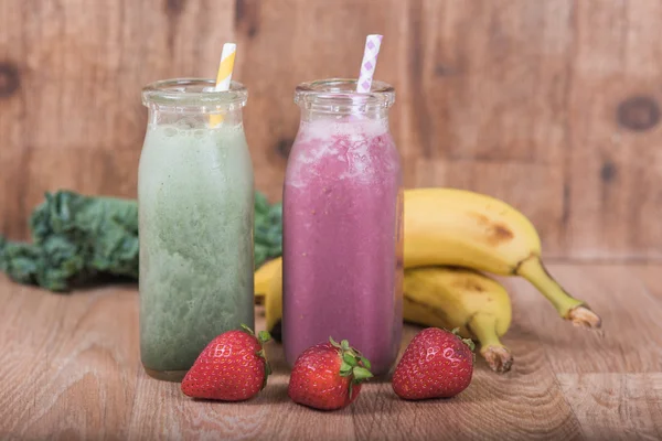 Två smoothie skakar i mjölkflaskor med färsk frukt — Stockfoto