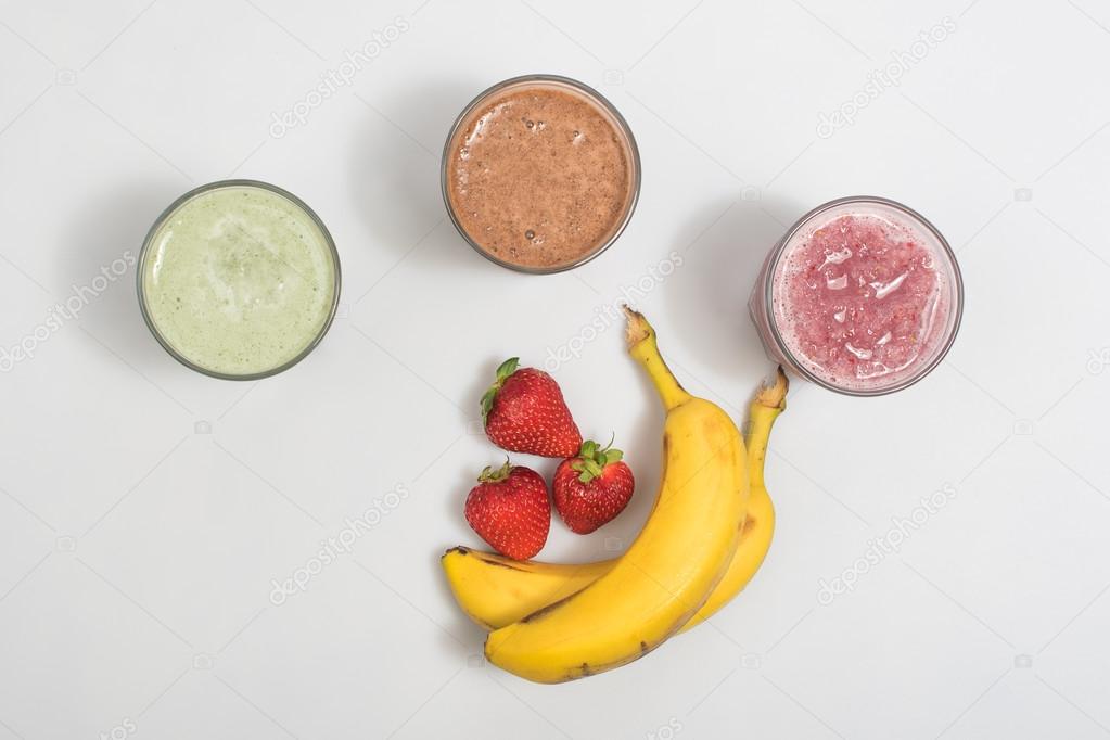Three smoothie shakes with bananas and strawberries