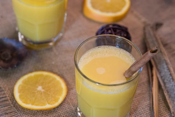 Rustic orange juice drink with cinnamon stick — Stock Photo, Image