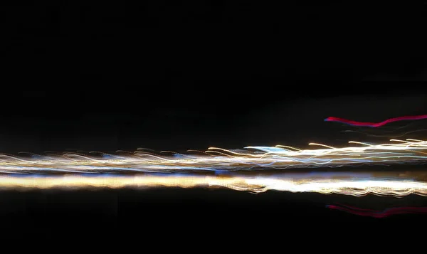 Işıl ışıl şerit, suyun üzerinde çok renkli bir ateş gibi hızla ilerler. Siyah üzerine izole edilmiş hızlı bir arka plan.