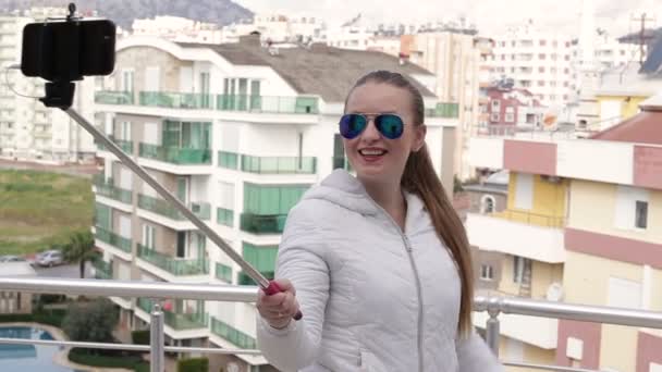 Jovem mulher feliz tomando auto retrato de pé no telhado da casa usando câmera de telefone celular smartphone. Fecha a porta. HD 1920x1080 . — Vídeo de Stock