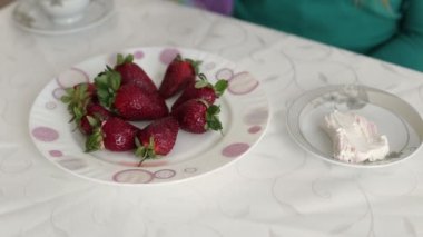 El alır bir taze sulu çilek, içinde yoğurt daldırma. Yakın çekim. HD 1920 x 1080