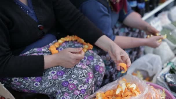 Vrouwelijke hand geplukt uit de schillen van sinaasappels. Close-up. — Stockvideo