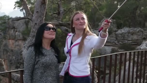 Duas jovens mulheres bonitas fotografando-se usando telefone inteligente. Close-up . — Vídeo de Stock