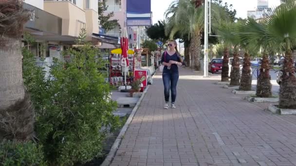 Felice bella giovane ragazza attiva che cammina lungo la strada con una bottiglia d'acqua in mano — Video Stock