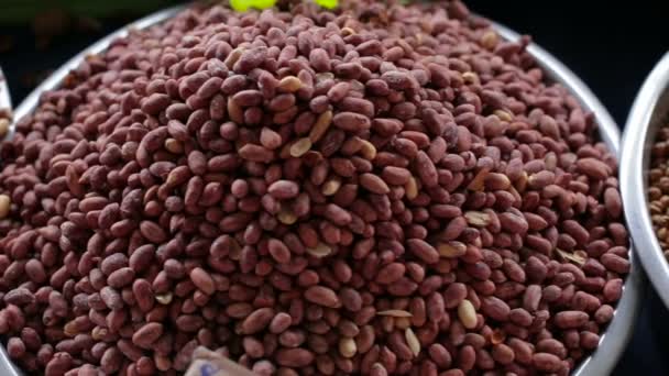 Recipientes com diferentes tipos de castanhas castanha de caju, avelãs, amendoins no mercado — Vídeo de Stock