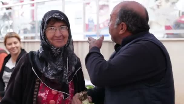 Antalya, Turquia - Março de 2016: Um homem e uma mulher estão sorrindo e abraçando, um homem segurando um pacote de alface — Vídeo de Stock