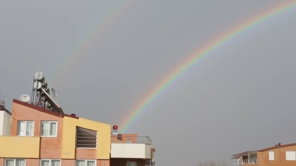 Grande arco-íris colorido no céu após a chuva acima dos telhados — Vídeo de Stock