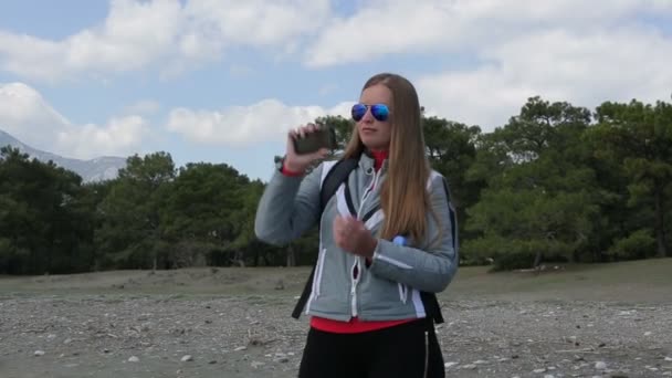 Menina alegre bonita fazer um panorama de fotos usar um smartphone — Vídeo de Stock