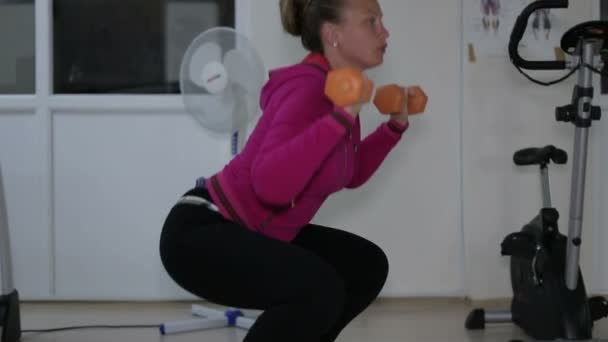 Jeune belle fille va dans le sport utiliser un haltère dans la salle de gym — Video