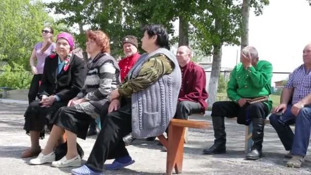 Koergan, Rusland - mei 2016: ouderen zittend op banken buiten in de zomer — Stockvideo
