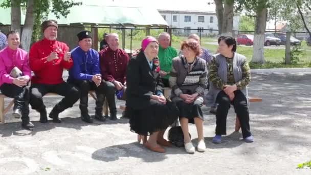 Kurgan, Rusia - mayo de 2016: ancianos sentados en bancos en verano — Vídeo de stock