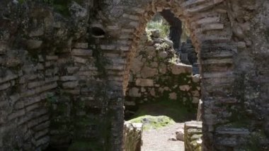 Genç güzel kız bir turist antik taş kemer dağlarda yürür