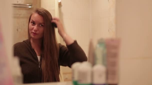 Menina penteando seu cabelo longo no banheiro — Vídeo de Stock