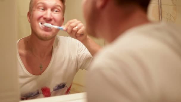 Un hombre cepillándose los dientes en el baño en casa — Vídeo de stock