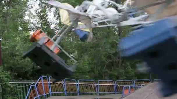 Duas crianças montam no carrossel em um parque de diversões — Vídeo de Stock