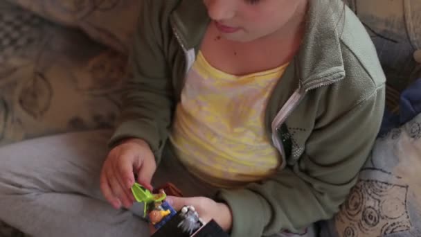 Uma menina está jogando em casa sentado no sofá — Vídeo de Stock