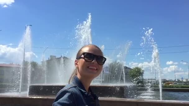 Girl near the fountain is turned, slow mo — Stock Video