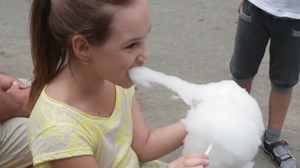 Petite fille joyeuse mange de la barbe à papa, gros plan — Video