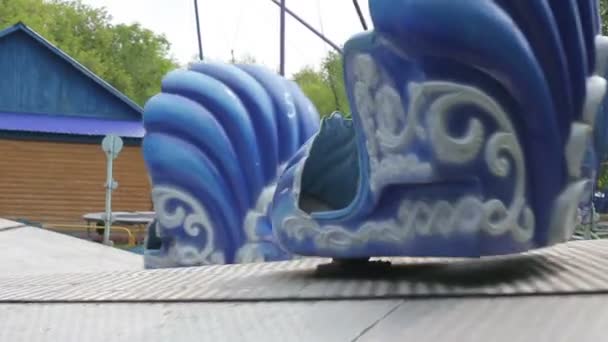 Duas crianças montam no carrossel em um parque de diversões — Vídeo de Stock