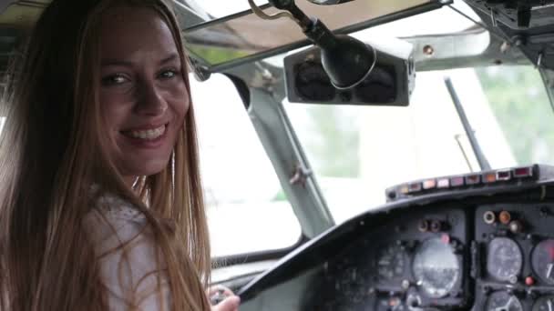 Beautiful young girl pilot sitting at the controls of an airplane — Stock Video
