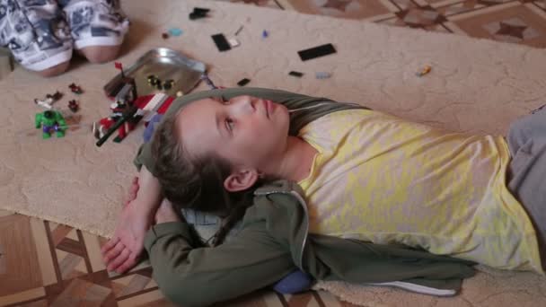 Menino e menina estão jogando em casa sentado no tapete — Vídeo de Stock