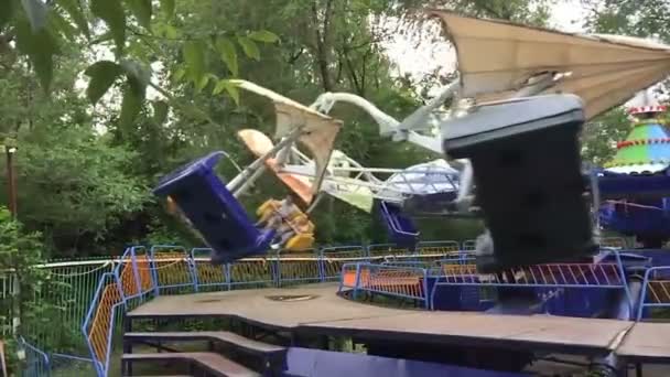 Deux enfants montent sur le carrousel dans un parc d'attractions, slow mo — Video