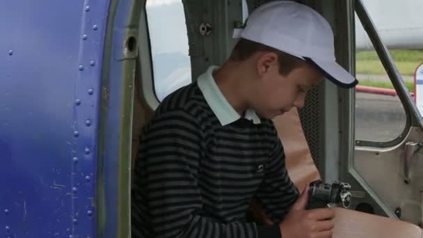 Le garçon est assis dans le cockpit de l'hélicoptère à la barre — Video