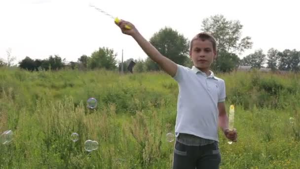 Boy blowing soap bubbles — Stock Video