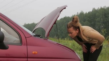 Kadın arabanın kaputu kapatır